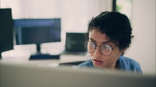 A young woman programmer working on artificial intelligence and coding at computer in office, concept of innovation, research, and modern technology.