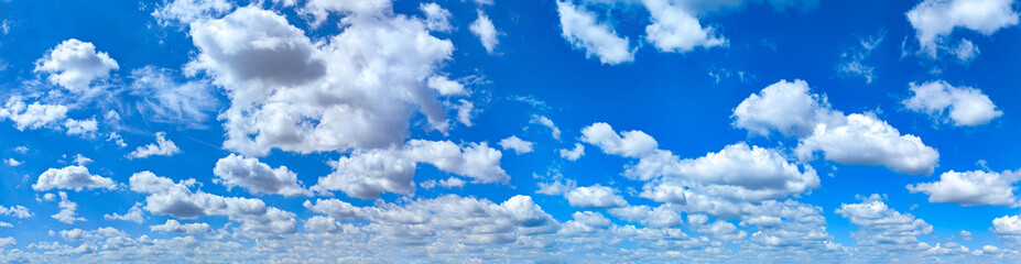 Fototapeta premium Beautiful clouds on deep blue sky background. Elegant white clouds in daylight after rain. Panorama glowing soft white fluffy clouds covered surface. Cumulus clouds against normal clear light day