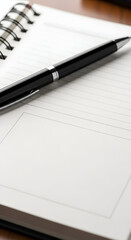 Black pen resting on an open spiral notebook