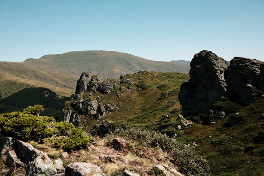 Rocky cliffs and green slopes of Stara Planina with mountain ridges in the distance. Babin Zub mount in summer season. Serbia country