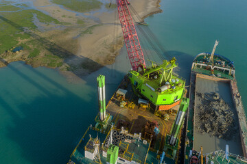 Floating Crane Barge Dredging Sediment Near Coastline
