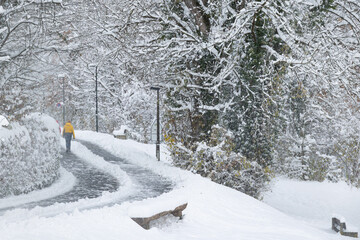 Person in a yellow jacket walking in a snowstorm
