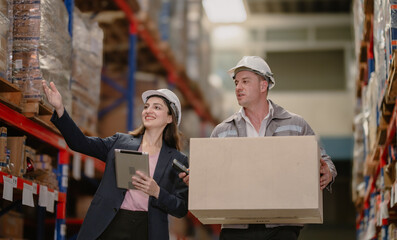 Distribution warehouse manager and client businesswoman using digital tablet checking inventory storage on shelf. Storehouse business worker and logistic engineer standing together at storage service