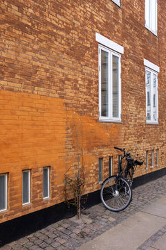 Bicycle leaning against brick facade in Nyboder Copenhagen Denmark, historic ochre houses representing heritage, urban lifestyle, architecture and sustainable city identity