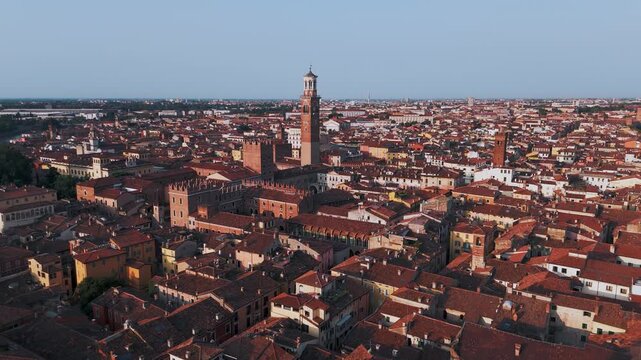 Aerial Drone Wide Approach Shot Of Torre Dei Lamberti And Piazza Delle Erbe In Verona, Italy At Sunrise On A Summer Morning.