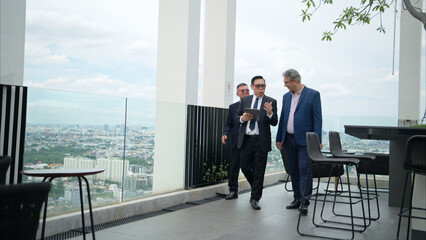 Business team working together on a laptop during an outdoor meeting