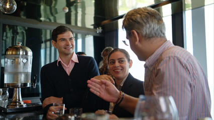 Smiling bartender serving drinks to customers at a modern bar
