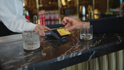 Smiling bartender serving drinks to customers at a modern bar