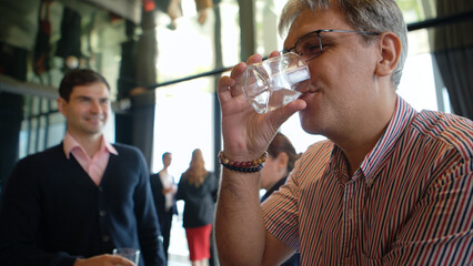Smiling bartender serving drinks to customers at a modern bar