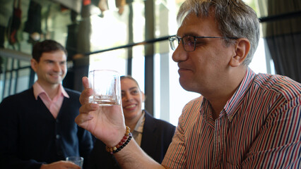 Smiling bartender serving drinks to customers at a modern bar
