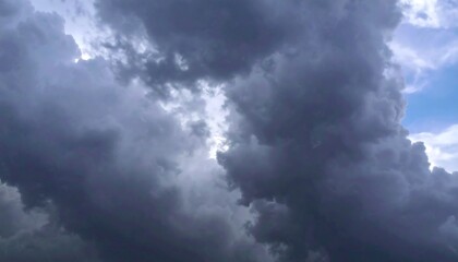 Dense, dark clouds fill most of the frame, with a sliver of blue sky visible through a break in the clouds