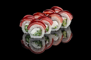 Japanese sushi rolls with tuna cucumber and cream cheese on black background