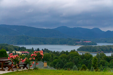 Solina Lake in the Bieszczady Mountains, view of mountains and water from terrace with flowers, picturesque tourist landscape © Adam