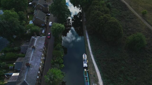 Aerial dusk view of Government Row, Enfield Island Village, showing rooftops, streets, and the River Lea Navigation with soft evening light.