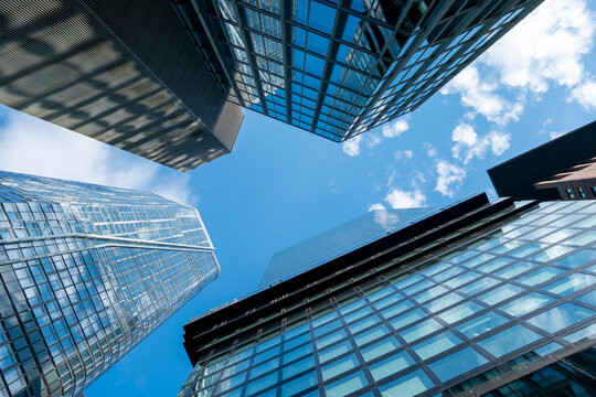 Frankfurt financial district skyscrapers viewed from below against blue sky, symbolizing finance, economy, business power, corporate identity, banking and investment architecture