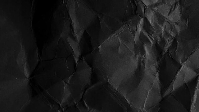 Dark crumpled paper texture with deep shadows black