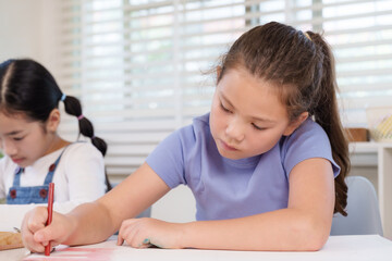 Obraz premium Caucasian preteen girl shading picture on notebook with pencil while asian schoolmate assists classroom art task elementary lesson teamwork creativity learning diligence progress achievement