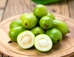 Fresh guavas displayed on wooden board showing cross section and texture