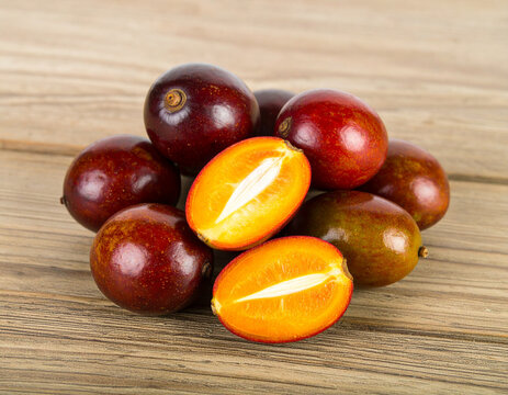 Fresh lilly pilly fruits displayed cut open on rustic wooden table