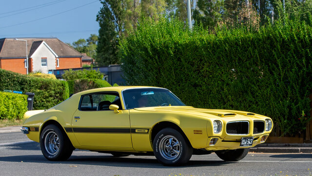 Bletchley,Bucks,UK - Aug 25th 2025: 1972 yellow Pontiac Firebird American classic  car driving on a British road