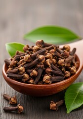 Obraz premium Aromatic cloves in wooden spoon against warm textured wood creating culinary bliss