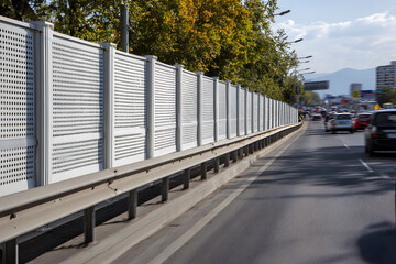 Obraz premium Soundproof fence with acoustic panels along the highway, protecting residential buildings in the microdistrict