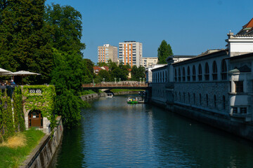 Fototapeta premium Ljubljana Canal Scene with Boats on the Ljubljanica River and Historic Bridges in the Heart of the City