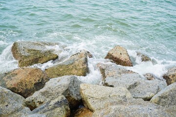 Waves crashing on rocks on the beach. Stone,sand,sea water and beach with lighting. sea rock bay cliff blue