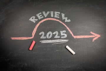 Year 2025 review concept drawn with chalk on blackboard with red arrow and white underline