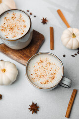 Cozy autumn drink with cinnamon and pumpkin spice in mugs, winter beverage with coffee beans