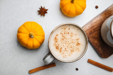 Warm pumpkin spice latte with cinnamon and star anise on a table