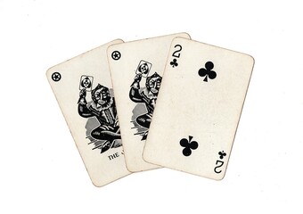 A hand of vintage playing cards showing a pair of jokers and one other card on a white background.
