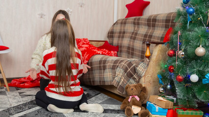 Christmas at home and daughter with mother hugs in the living room.