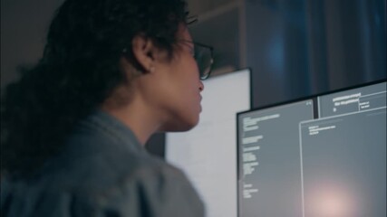Professional woman programmer focused on coding late at night, working on artificial intelligence, cybersecurity, cloud computing, and network security in a modern office environment. - Powered by Adobe