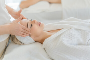 Woman receiving relaxing head massage in spa for stress relief, self-care, and mental wellness. Natural therapy for burnout recovery.