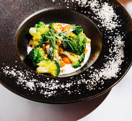 Elegant vegetable dish featuring broccoli and pine nuts with creamy sauce