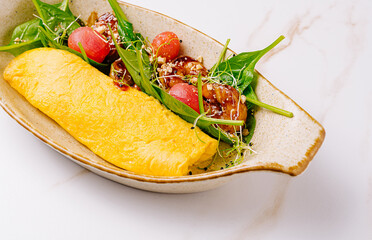 Delicious omelet served with fresh vegetables and sauce in a bowl