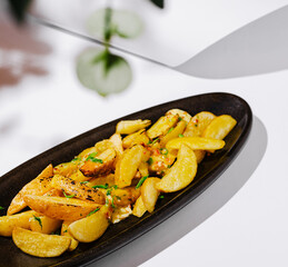 Delicious golden roasted potatoes served on a stylish black platter