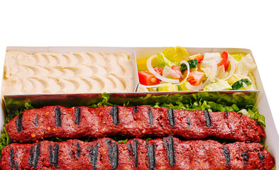 Delicious grilled kebabs served with fresh salad and creamy dip