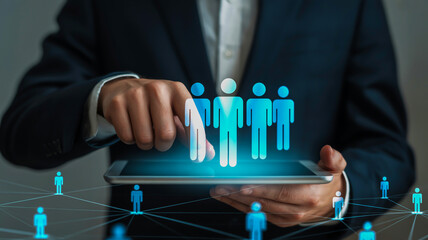Person in dark suit touching glowing blue human figures on tablet screen business technology