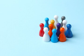 Unity concept. Group of color pawns on blue table. 