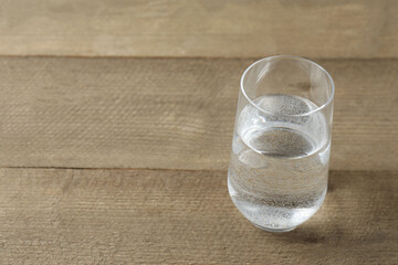 Glass with water on a wooden table. Drinking clear water 