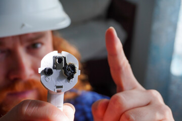 Quality control example showing hand holding plug with melted tips. Highlights need for inspection and repair.