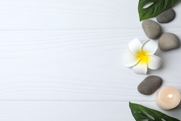 Top view of spa stones set for massage with green leaves on black concrete background with copy space. Elegant spa. Flat lay, mock up, template. Health and beauty concept