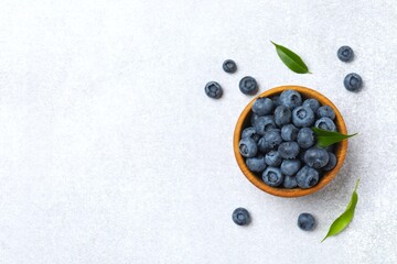 Top view of bowl with fresh tasty blueberries on gray table, close up