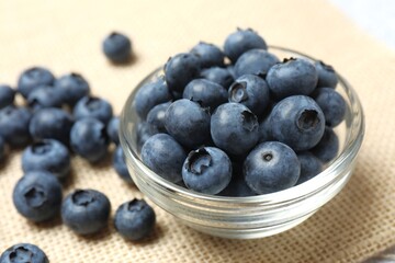 Delicious fresh blueberries in a bowl on the table, close-up