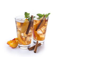Refreshing peach iced tea in glass with ice cubes and cinnamon isolated on white background. Copy space