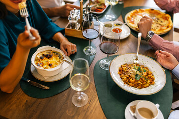 Top View of Hands Eating Lunch with Food and Wine at Restaurant