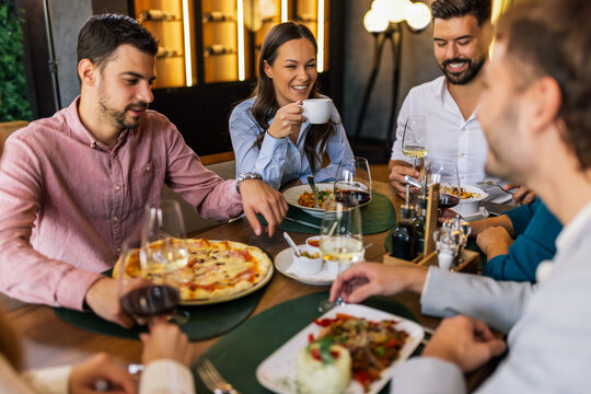 Colleagues Enjoying Lunch with Food and Wine at Restaurant - Powered by Adobe