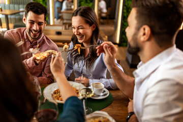 Friends Playfully Feeding Woman at Restaurant Lunch